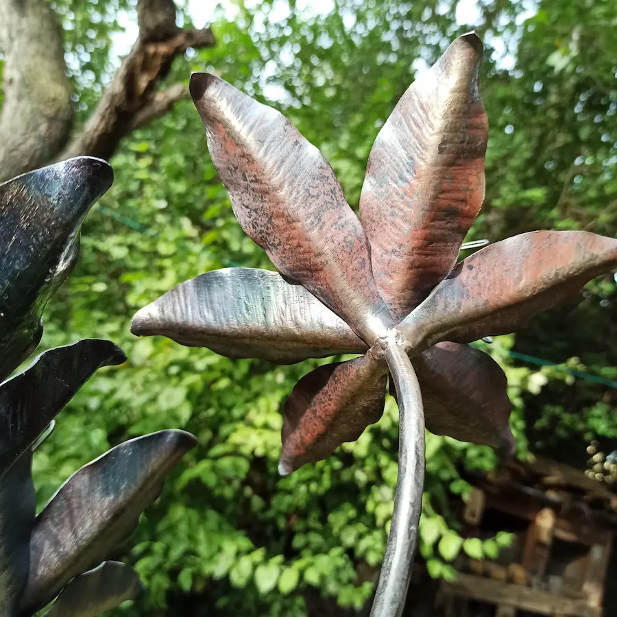 Handgefertigte Stahl-Lilie mit Rost- und Anlauffarben als Gartendeko – Rückseite